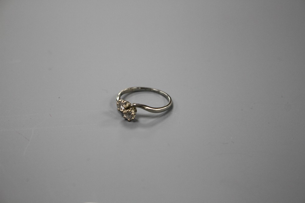 An 18ct and Plat, two stone diamond crossover ring, size P/Q, gross weight 2.5 grams.